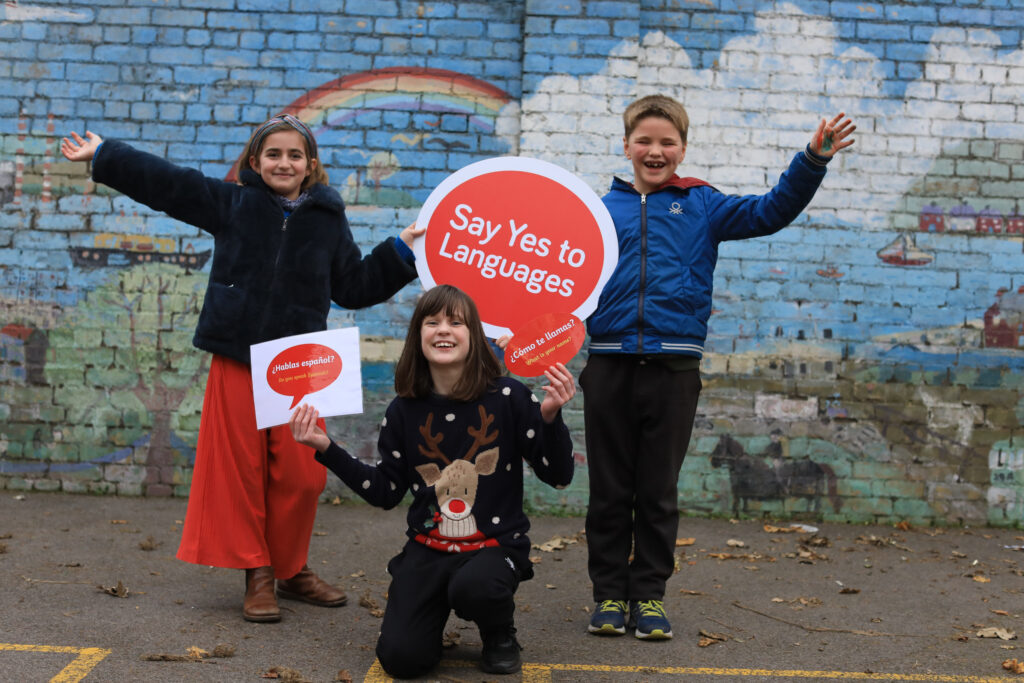 Primary school sampler participants pose with say yes to languages signs