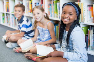 Portrait of Smiling Kids Sitting on Floor and Reading