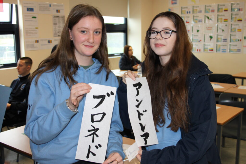 Girls holding their names up in Japanese